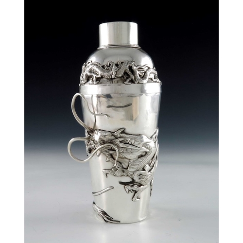 10 - A Chinese silver cocktail shaker, circa 1920, the body applied with a cast dragon in relief amongst ... 