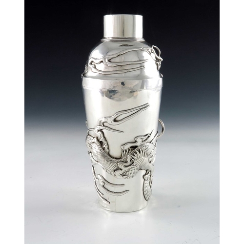 10 - A Chinese silver cocktail shaker, circa 1920, the body applied with a cast dragon in relief amongst ... 