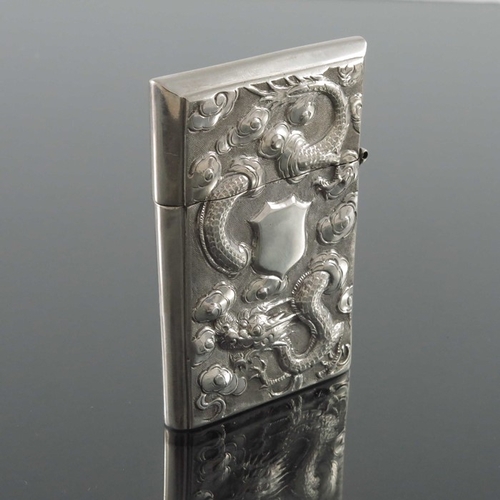 5 - A Chinese silver card case, circa 1900, embossed in relief with a dragon amongst clouds, the reverse... 