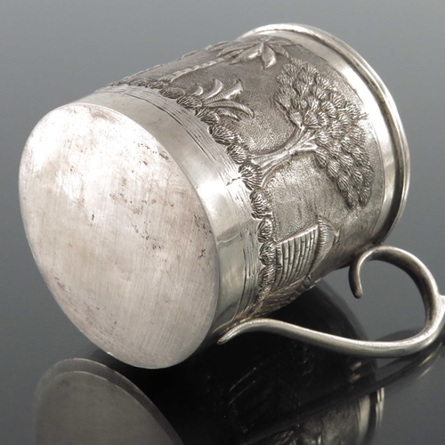 8 - An Indian white metal mug, late 19th century, cylindrical form, repousse embossed and chased with tr... 