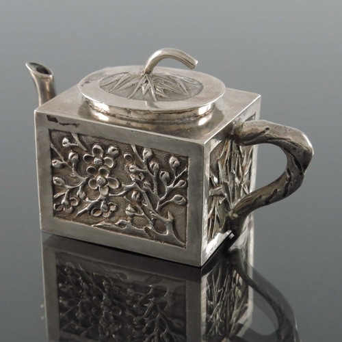 11 - A Chinese export miniature silver teapot, Wing Fat, circa 1900, cuboid form, embossed and chased wit... 