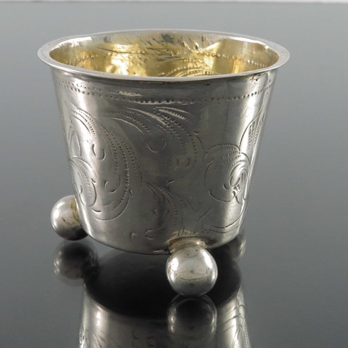 52 - An 18th century Swedish silver and parcel gilt beaker, Stockholm 1705, conical form of three ball fe... 