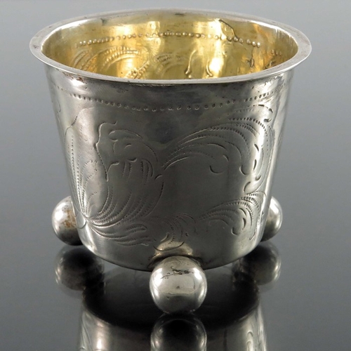 52 - An 18th century Swedish silver and parcel gilt beaker, Stockholm 1705, conical form of three ball fe... 