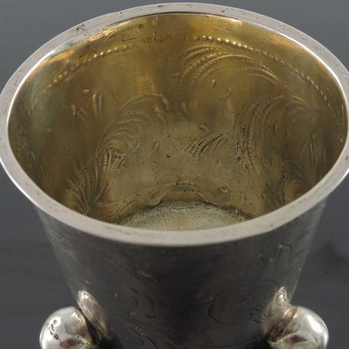 52 - An 18th century Swedish silver and parcel gilt beaker, Stockholm 1705, conical form of three ball fe... 