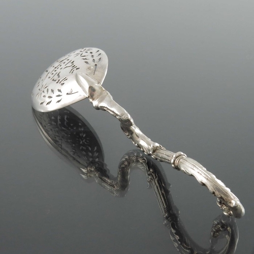 58 - A Dutch silver sifter spoon, the pierced bowl on a cast zoomorphic foliate griffin stem, 14cm long, ... 