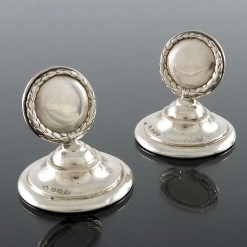 125 - A pair of Edwardian silver menu holders, Elkington and Co., Birmingham 1908, laurel wreath plates wi... 