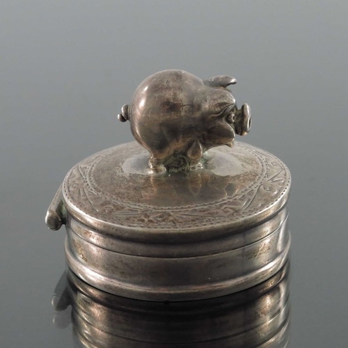 157 - An Elizabeth II silver tooth box, Ari Norman, London 2000, circular with hinged lid and cast figure ... 