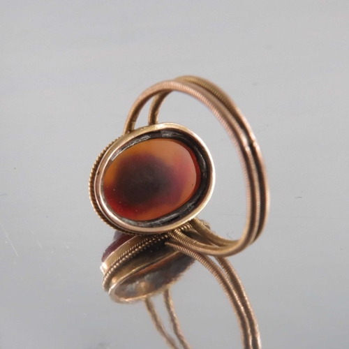 268 - A Revivalist yellow metal and carved carnelian ring, in the style of Castellani, the central stone m... 