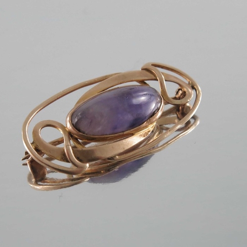 273 - Archibald Knox for Liberty and Co., an Arts and Crafts amethyst and gold brooch, the central cabocho... 