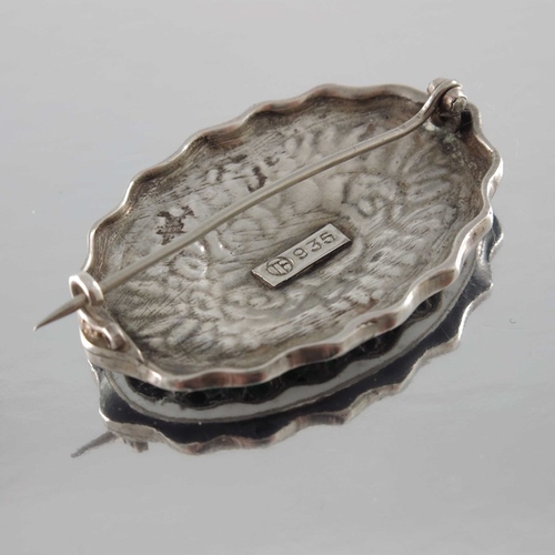 279 - Theodor Fahrner, a Jugendstil silver and enamelled brooch, crimped oval form with central bouquet of... 