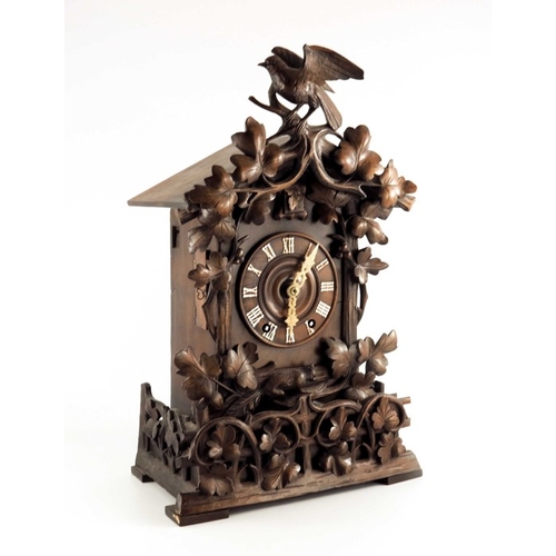 388 - A 19th century Black Forest carved Swiss cuckoo clock, the 5.5 inch dial with bone hands, within a p... 