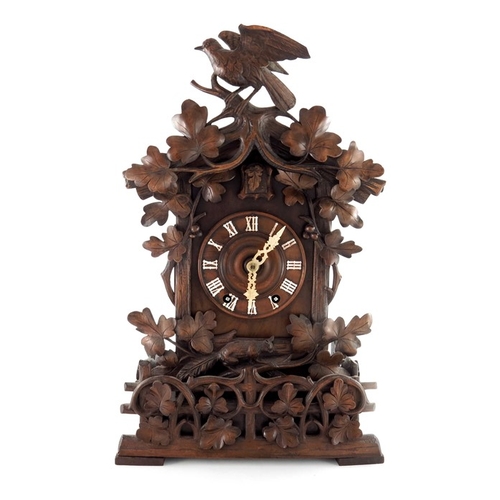 388 - A 19th century Black Forest carved Swiss cuckoo clock, the 5.5 inch dial with bone hands, within a p... 