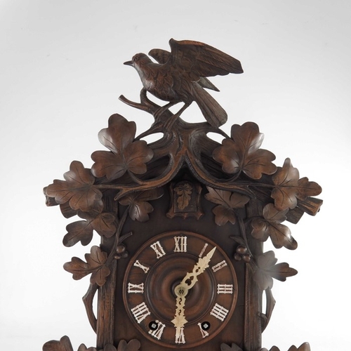 388 - A 19th century Black Forest carved Swiss cuckoo clock, the 5.5 inch dial with bone hands, within a p... 