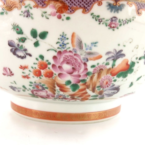 404 - An 18th century Chinese famille rose punch bowl, Qianlong, painted with trellis cartouches and husk ... 