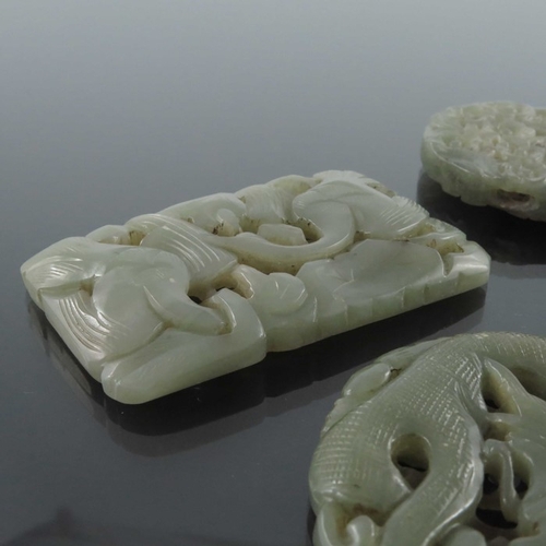 413 - Four Chinese reticulated carved jade pendants, including circular coiled dragon, goose and foliate s... 