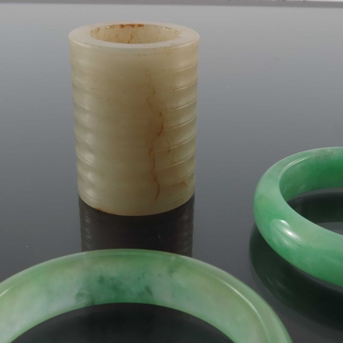 415 - Two Chinese jade type carved stone bangles and a ring, internal diameter 6cm (3)