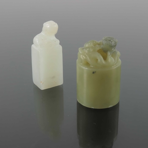 416 - Two Chinese carved jade seals, both with lions to the finials, one white, 4.5cm high (2)