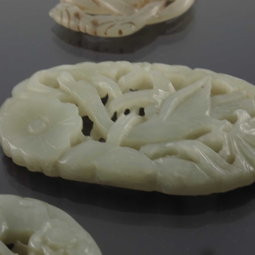 421 - Four Chinese reticulated jade pendants, including knotted serpents, dragon and birds, 7.5cm (4)