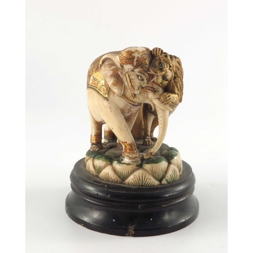 435 - ? A 19th century carved and painted ivory figure group, modelled as a lion attacking an elephant gil... 