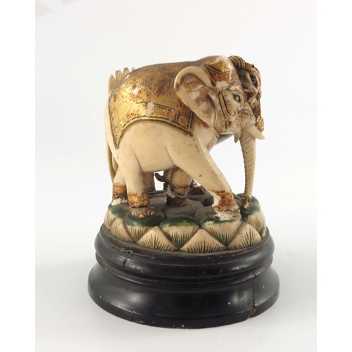 435 - ? A 19th century carved and painted ivory figure group, modelled as a lion attacking an elephant gil... 