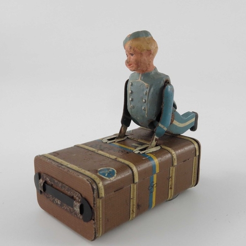 477 - A Schuco Express Boy clockwork tin toy, modelled as a porter with luggage, 8.5cm long