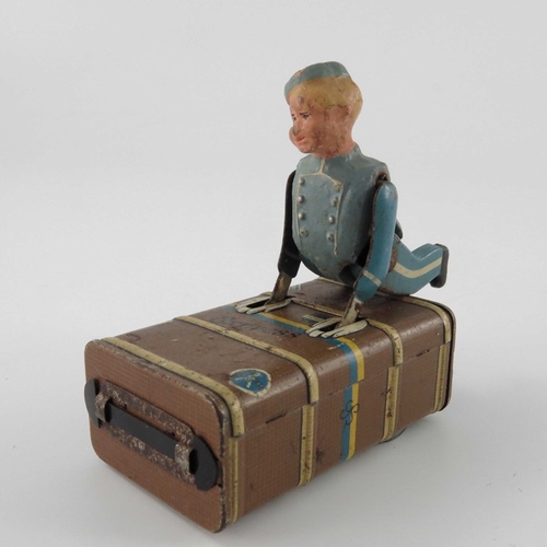 477 - A Schuco Express Boy clockwork tin toy, modelled as a porter with luggage, 8.5cm long