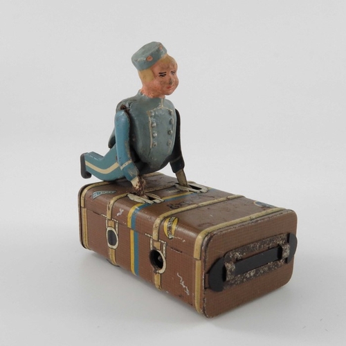 477 - A Schuco Express Boy clockwork tin toy, modelled as a porter with luggage, 8.5cm long