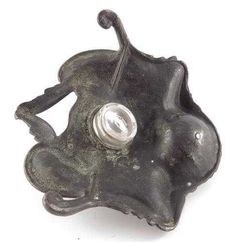 493 - N Vidal, an Art Nouveau bronzed inkwell, cast in relief with foliate scrolls and shells, faceted gla... 