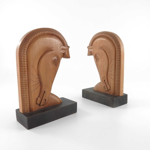 497 - A pair of Art Deco carved wooden bookends, in the style of Laszlo Hoenig, beech on ebonised bases, m... 