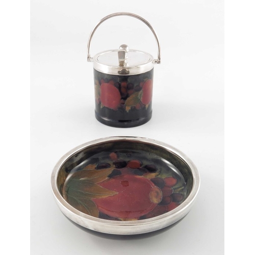 633 - William Moorcroft, a Pomegranate on ochre dish and a jam pot, with plated mounts, circa 1915, plain ... 