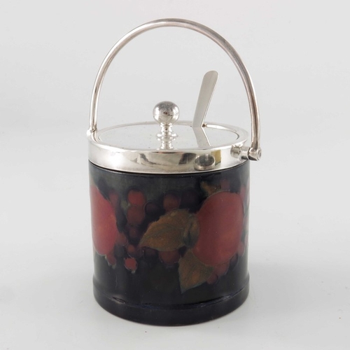 633 - William Moorcroft, a Pomegranate on ochre dish and a jam pot, with plated mounts, circa 1915, plain ... 