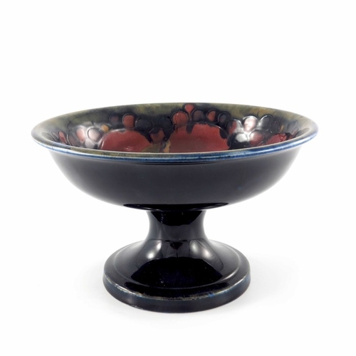 640 - William Moorcroft, a Pomegranate on ochre and blue tazza, circa 1918, circular with everted rim on s... 