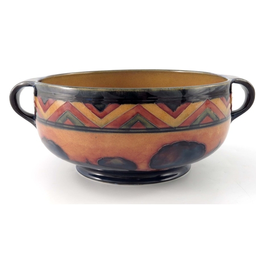 645 - William Moorcroft, a red Dawn Landscape bowl, circa 1925, twin handled rounded form, impressed marks... 