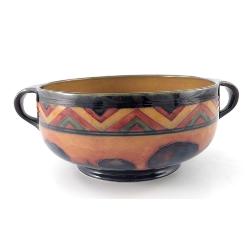 645 - William Moorcroft, a red Dawn Landscape bowl, circa 1925, twin handled rounded form, impressed marks... 