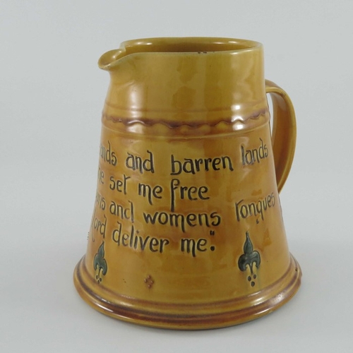 653 - C H Brannam for Liberty and Co., an art pottery motto jug, circa 1915, treacle glazed conical form, ... 