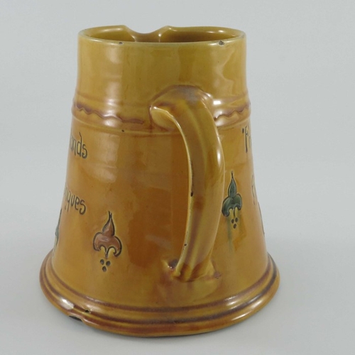 653 - C H Brannam for Liberty and Co., an art pottery motto jug, circa 1915, treacle glazed conical form, ... 