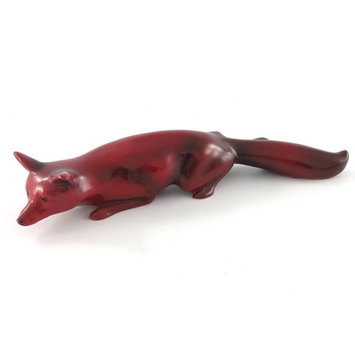 684 - Charles Noke for Royal Doulton, a Flambe fox figure, modelled crouching, 22cm long