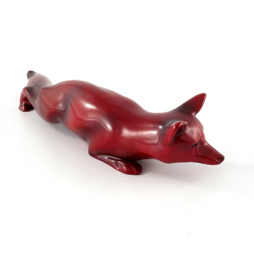 684 - Charles Noke for Royal Doulton, a Flambe fox figure, modelled crouching, 22cm long