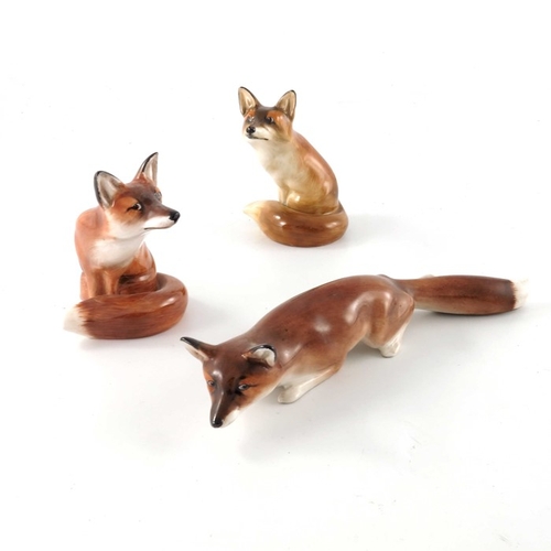 753 - Charles Noke for Royal Doulton, three fox figures, HN147 and HN130, two modelled sitting, in differe... 