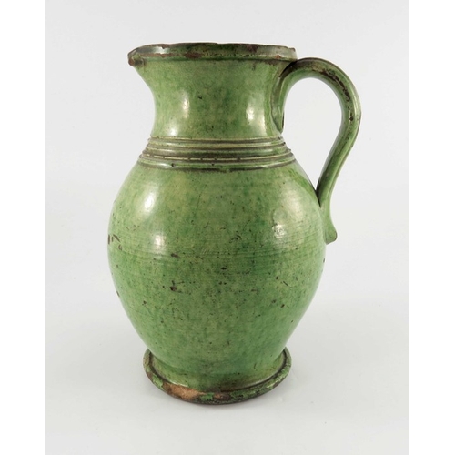 771 - A 19th century green glazed earthenware jug, possibly Farnham, ovoid form, incised to the shoulder w... 