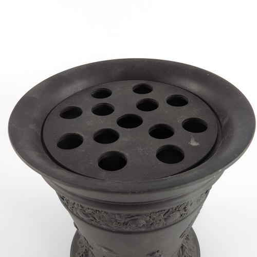 774 - A Wedgwood black basalt vase, circa 1850s, footed conical form, with pierced grille, applied with Cl... 