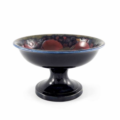 640 - William Moorcroft, a Pomegranate on ochre and blue tazza, circa 1918, circular with everted rim on s... 