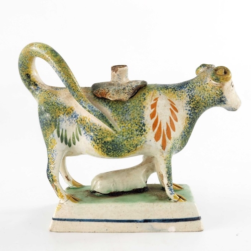 789 - A Staffordshire Prattware sponge decorated cow creamer, modelled standing, with calf below, on plint... 