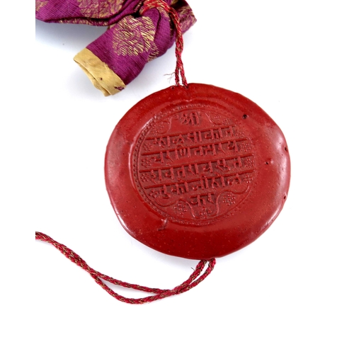 439a - India, an antique Indian round wax seal attached to a silk bag, indistinct English inscription on ve... 