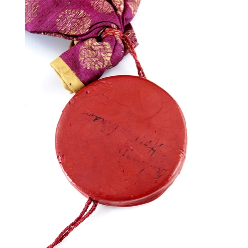 439a - India, an antique Indian round wax seal attached to a silk bag, indistinct English inscription on ve... 