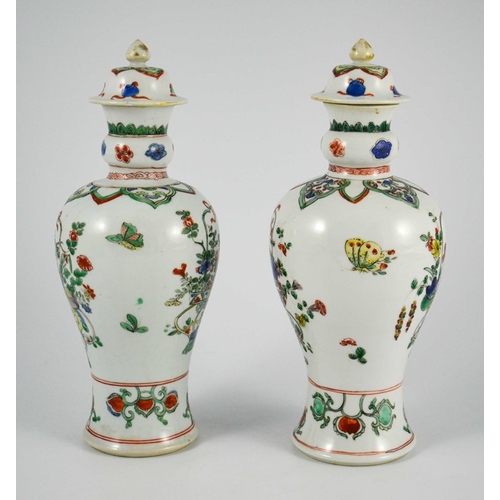 401A - A pair of Chinese famille vert baluster vases and covers, each decorated with floral motifs in polyc... 