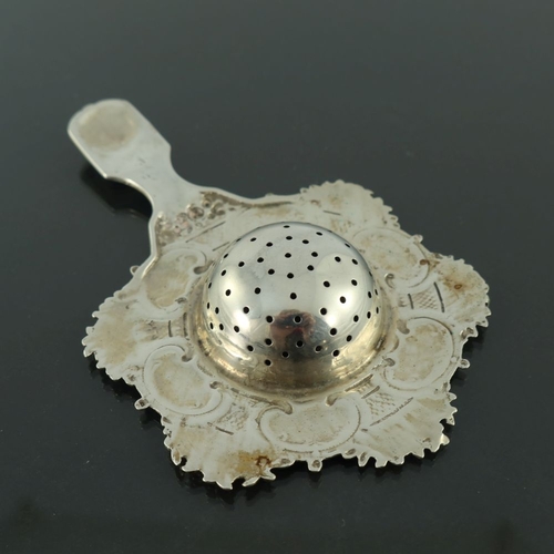 32 - A Continental silver tea strainer, circa 1900, cast with alternating floral basket and kidney scroll... 