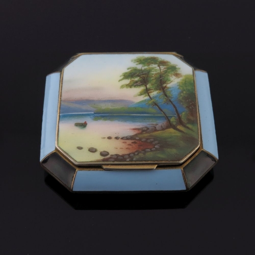 73 - A gilt metal octagonal enamel powder compact with a river landscape to the hinged cover within a blu... 