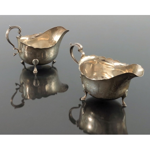 81 - A pair of George V silver sauce boats, Adie Brothers, Birmingham 1931, ogee rimed helmet form, with ... 