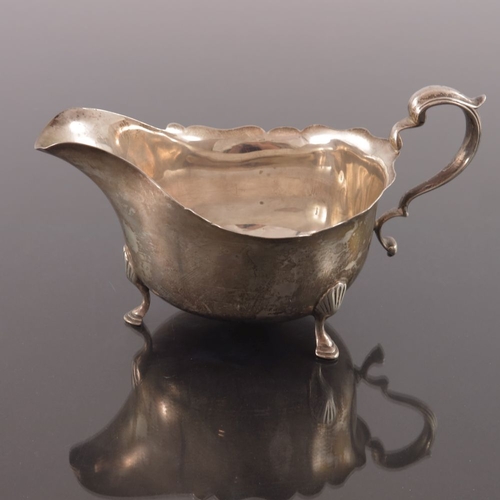 81 - A pair of George V silver sauce boats, Adie Brothers, Birmingham 1931, ogee rimed helmet form, with ... 